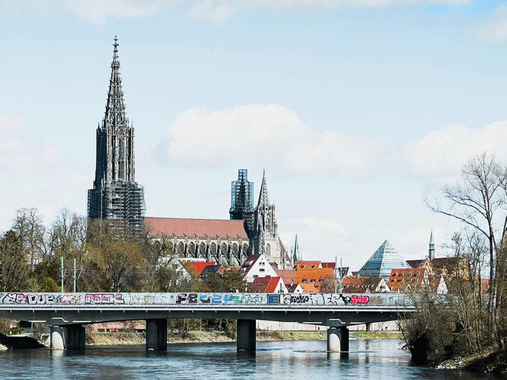 Ulmer Münster, fotografiert vom Fussgängersteg an der Adenauer Brücke mit Blick auf die Eisenbahnbrücke, Bibliothek Ulm und Ulmer Fischerviertel